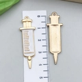 Detail of syringe-shaped alloy charm with white enamel front and golden brushed metal back - White Enamel Syringe 9x30mm (12005)