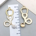 Detail view of a 40mm stethoscope charm with white enamel and sparkling crystal - White Stethoscope Style (23231) / 43x23mm