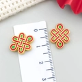 Macro shot of 1.5cm red enamel Chinese knot pendant with a ruler for size reference - Large Chinese Knot Spacer Bead (22839) / 1 Piece/Pack (16x12mm) / Matte Antique Gold