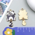 Pendentif chat pirate en émail avec cache-œil cœur violet et base en métal doré - Noir