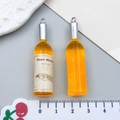 Miniatur-Weinanhänger aus orangefarbenem Harz mit silbernen Ringen und Bordeaux-Etiketten - Orange Harz Weinflasche