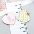Ciondolo a cuore in smalto rosa con nastro e retro dorato mostrato con un righello - Stile Fiocco Cuore Olio di Gocciolamento Rosa (24875)