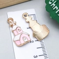 Pink and white enamel church charm with gold trim and size scale reference - Pink Enamel Christmas Castle