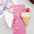 Macro shot of resin ice cream cone pendants showing front and back details with ruler - White