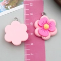Pink resin sunflower pendant with silver ring shown next to a ruler for size - Pink Resin Double Plum Style