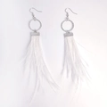 Detailed view of white feather tassel earrings with polished round metal rings and hooks - White
