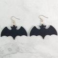 Pendientes de murciélago negro para Halloween con ganchos dorados sobre mármol - Forma de Murciélago