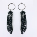 Gothic silver hoop earrings featuring black feathers with white spider web patterns - Spider Web