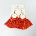 Handmade orange tassel hoop earrings with gold accents in bohemian style on display card - Orange