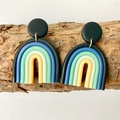Macro shot of U-shaped rainbow polymer clay earrings on a natural textured bark background - Black Blue Green Yellow Gradient Rainbow
