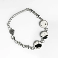 Detailed view of cow print leather charms and star pendants on a silver metal bracelet - Cow Print (4)