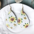 Detalle de pendientes de cuero en forma de gota con girasoles sobre un plato blanco - Estampado Gota Girasol (6)