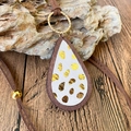 Macro shot of leopard print pendant on wooden base with leather cord necklace - Gold Polka Dot Style (3)