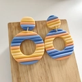 Macro shot of wavy polymer clay earrings in blue and orange on wood surface - Blue Pink Yellow Striped Style