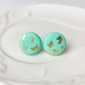 Close-up of mint green handmade clay stud earrings with gold foil on ceramic plate - Mint Green(5)