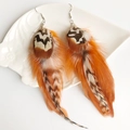 Close-up of bohemian orange natural feather earrings on a white ceramic display tray - Bright Orange Long Style (1)