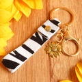 Detail of animal print horsehair keychain with golden sunflower charm on wood background - Gold Zebra Pattern