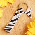 Zebra print leather keychain with cow head pendant and silver ring on wood background - Zebra Style