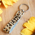 Dettaglio del portachiavi in pelle leopardata con anello argentato su legno - Stile Stampa Leopardata Scura (4838918343672)