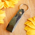Close-up of camouflage leopard print horsehair leather keychain on a wooden surface - Camouflage Green Style (4838918343674)