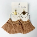 Detailed shot of golden hoop earrings featuring handmade tan tassel and woven fringe - Tan