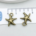 Detailed view of antique bronze starfish charms with ruler showing 1.8cm size - Starfish (1675)