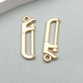 Detail of two gold saw charms for DIY jewelry making with a polished metallic finish - 1 Piece KC Gold Saw Shape (18334)