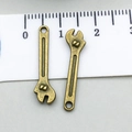 Macro detail of antique bronze wrench charms showing intricate texture and mounting holes - Wrench (17384)