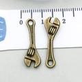 Detail showing two mini antique bronze wrench charms with measurement ruler for size reference - Wrench (17383)