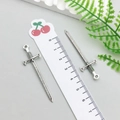 Macro shot of two vintage silver sword charms with ruler showing 5.5cm size detail - Antique Silver Sword (18720)