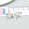 Close-up of vintage sewing machine charms in antique silver alloy with a size scale - Antique Silver Sewing Machine Style (6230)