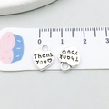 Dettaglio macro di un ciondolo a cuore in argento antico da 10 mm con incisione Thank You - Antique Silver Heart Letter (7026)