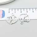 Macro di due ciondoli a cuore intrecciati con righello che mostra la scala di misura - Cuore Traforato Argento Antico (5801)