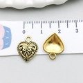 Macro view of vintage gold heart charm with embossed scrolls showing dimensions on a ruler - Antique Gold Pattern Heart (17590)