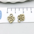 Dettaglio del ciondolo a cuore in bronzo da 12mm con incisione Made With Love per gioielli - Ciondolo con Lettera a Cuore (815)