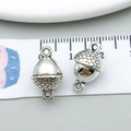Macro shot of silver acorn charms on scale measuring approximately 1.5 cm for jewelry DIY - Antique Silver Double Hole Pine Cone (5690)