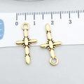 Golden cross pendants with bead design and oval segments shown next to a measuring ruler - Antique Gold Cross 23x12mm (20381)