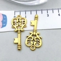 Macro shot of two vintage heart key charms in antique gold finish with detailed scale - Antique Gold Key (10230)