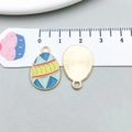 Macro detail of enamel Easter egg charms with geometric patterns and size scale - Blue and Yellow Egg (15140) / 14*22mm
