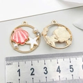 Detailed close-up of 25mm round shell and starfish charm pendants for DIY jewelry - Starfish Shell / Pink