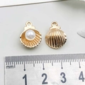 Detailed view of gold shell pendants with pearl inside and scale for size measurement - Shell / KC Gold