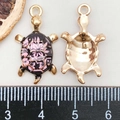 Detail of sea turtle pendant with black enamel shell and pink floral pattern with sizing tool - Printed Turtle / Purple