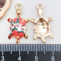 Macro shot of sea turtle pendant with size measurement showing 2cm length and floral enamel - Red