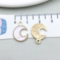 Detail view of crescent moon pendants with white enamel and golden star measured by ruler - Moon Design