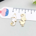 Macro detail of seahorse charm showing front white enamel and back gold plating with scale - Seahorse / White
