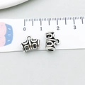 Macro view of antique silver alloy tube beads showing hollow geometric pattern and 11mm size - Antique Silver Bail 9x12mm (6534)