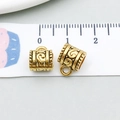 Detailed macro view of vintage gold alloy filigree charm pendant with size measurements - Antique Gold Scroll Bead (14333)