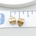Macro detail of KC gold vintage hollow cylinder pendant charm with measurement tape - Engraved Texture Style (16169)