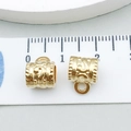 Macro view of KC gold alloy hollow spacer beads with 10mm measurement on a ruler - Embossed Hollow Style (20656)