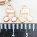 Detailed view of enamel musical note pendants with ruler showing size and texture - Pink Enamel Music Note Style (19437)